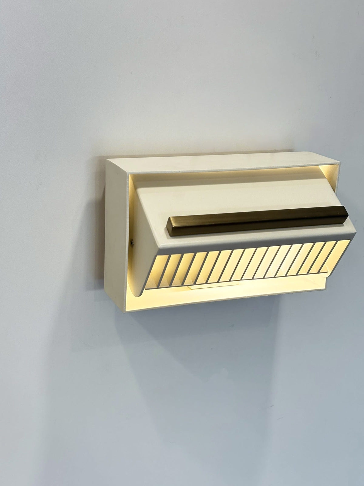 MURAFA louvered wall light with matte brass bar, front angled view
