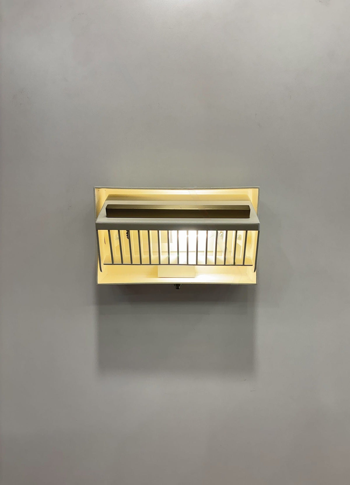 MURAFA wall sconce with tilted louvered head, front view lit