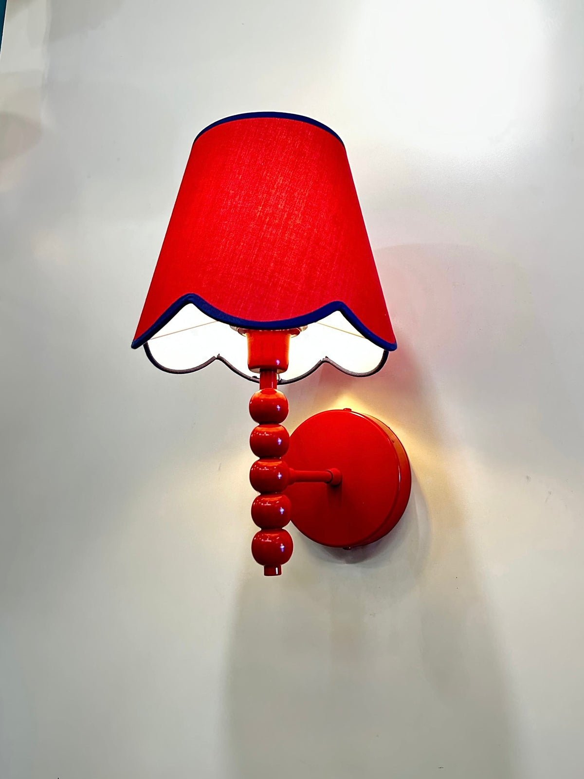 PROMIN red beaded wall sconce angled view with scalloped shade hem and white inner lining