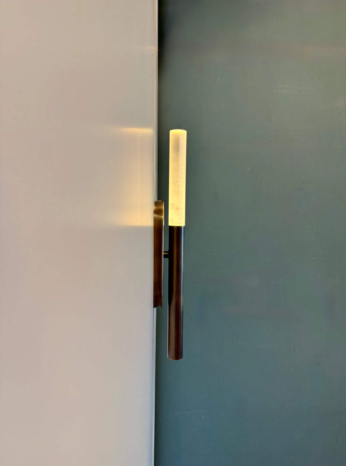 MUSALA slim vertical wall light seen from the side on a cream wall